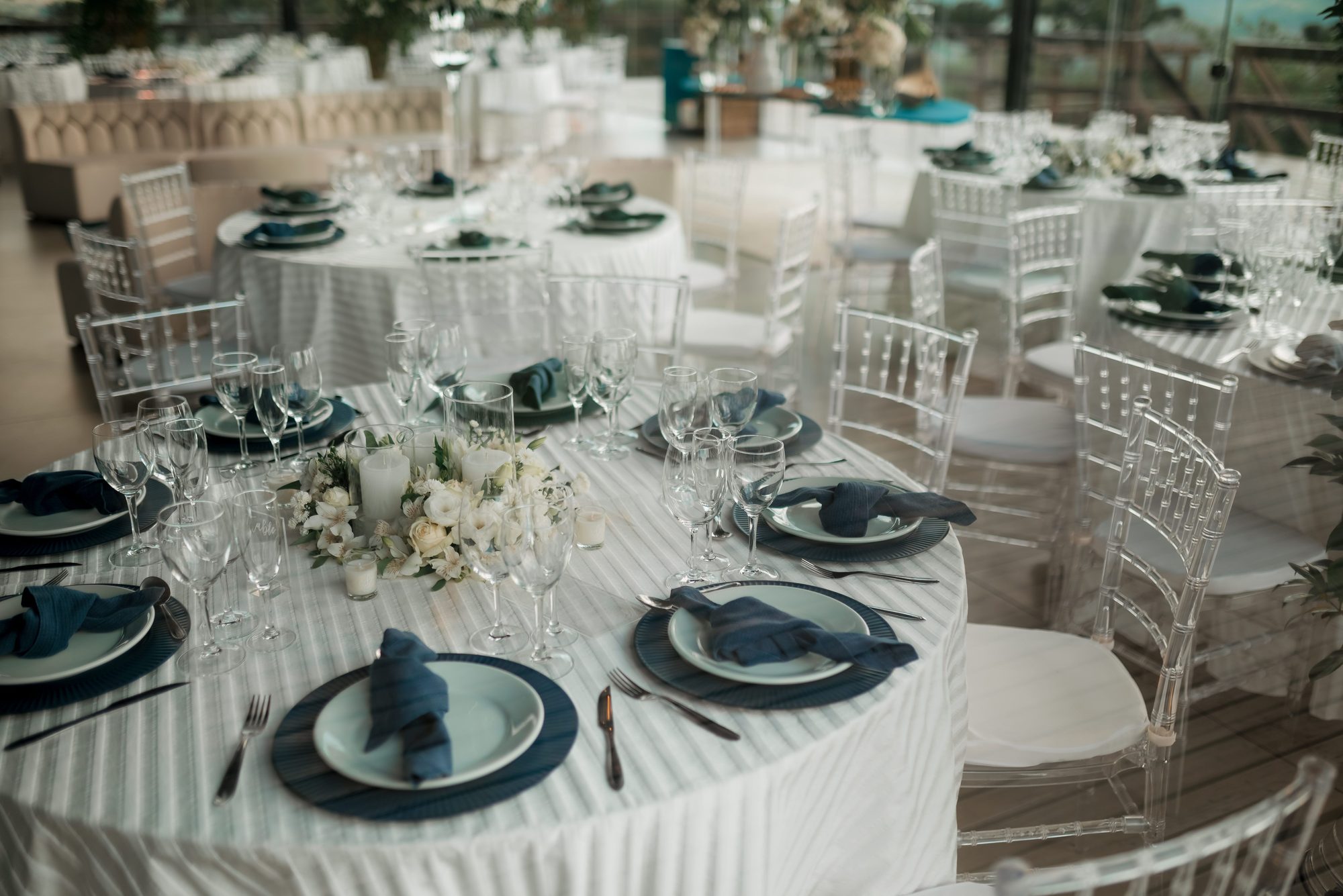Elegant place setting with navy napkins, crystal glassware, and white floral centerpiece